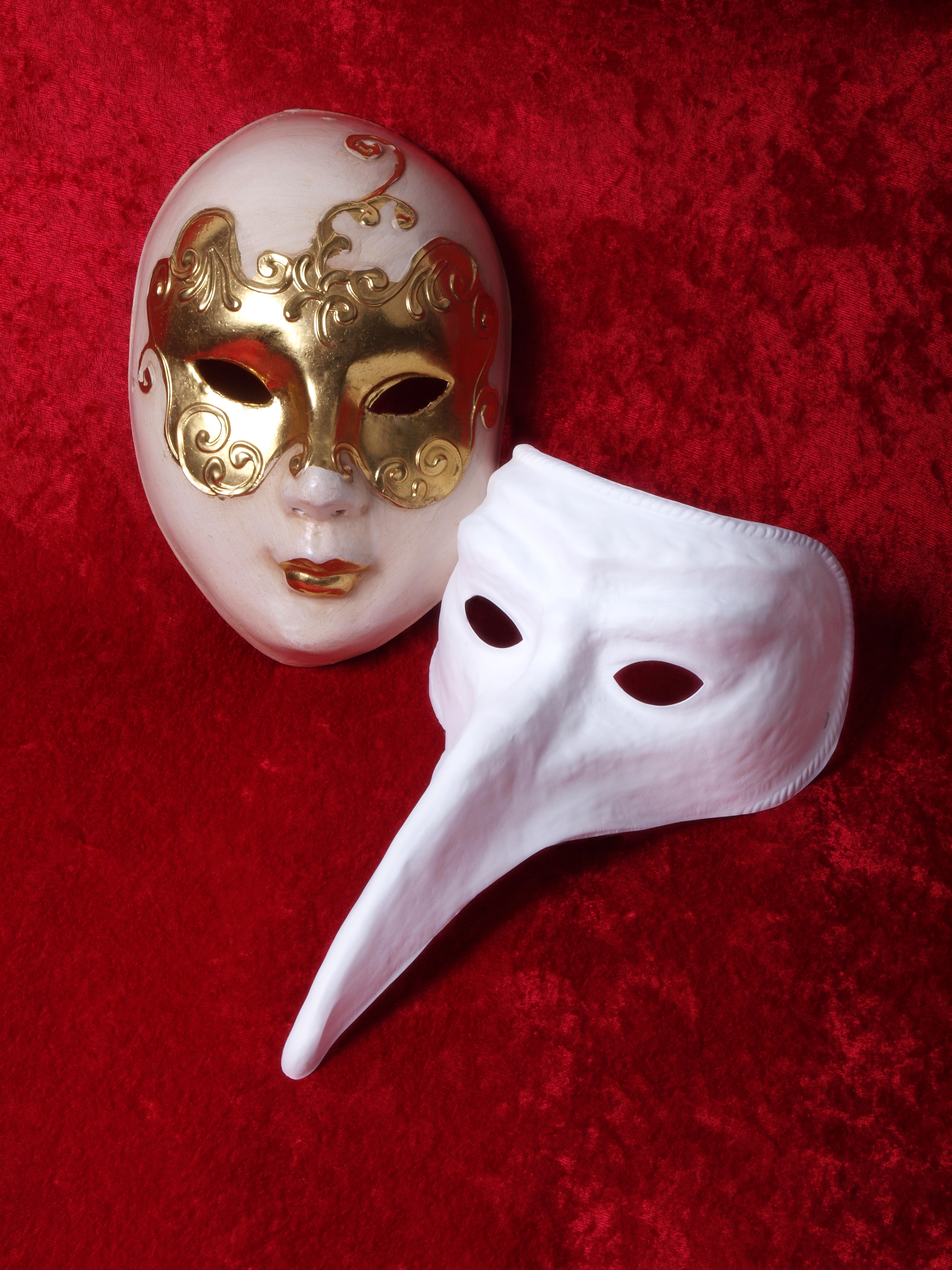 venetian and beak mask on red velevet background - theater or carnival concept